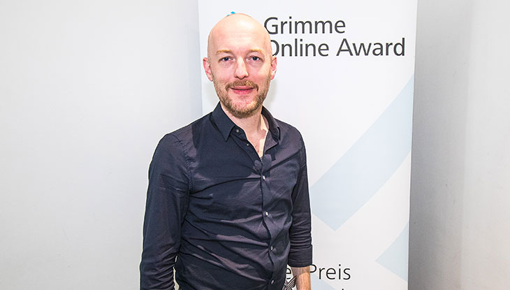 Boris Rosenkranz, Mitbegründer von "Übermedien", vor einem Rollup des Grimme Online Award; Foto: Rainer Keuenhof/Grimme-Institut